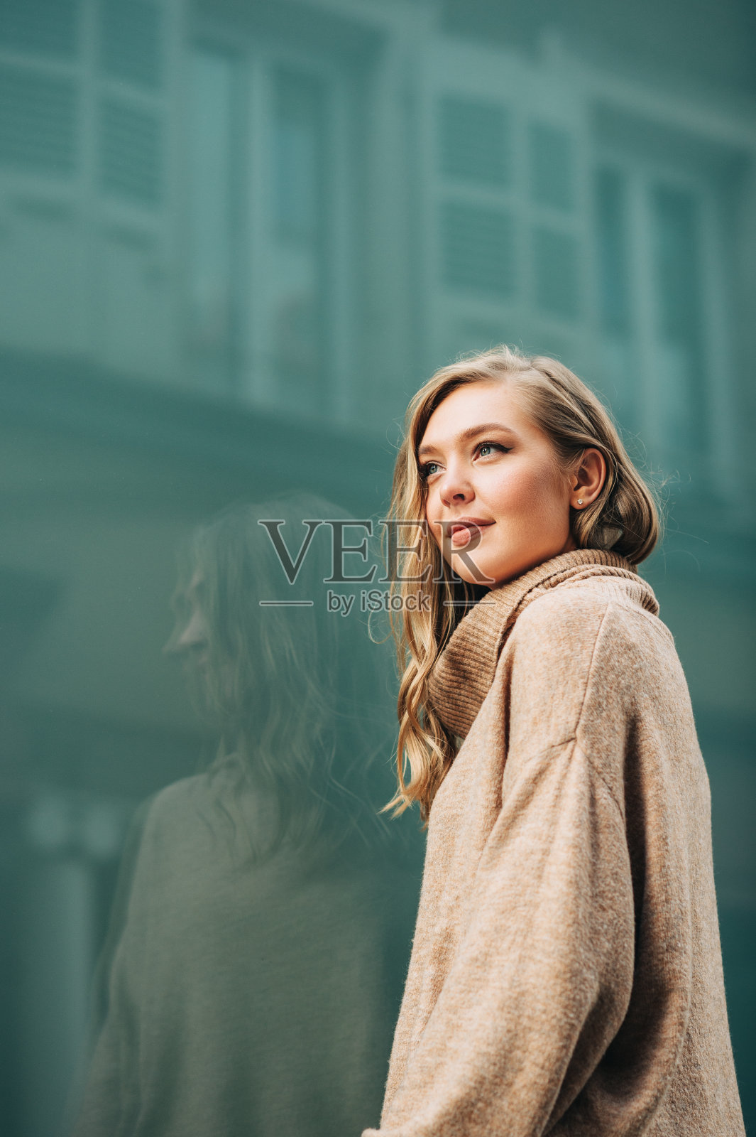 街头时尚的年轻美丽的女人穿着米色翻领套头衫的肖像照片摄影图片