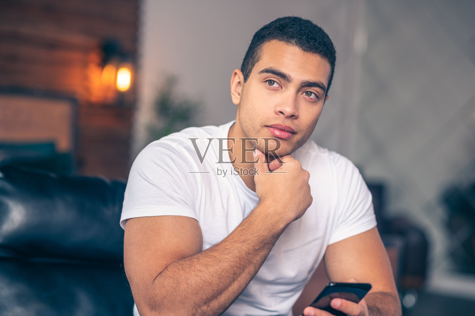 年轻的运动员沉思地看着一边。照片摄影图片