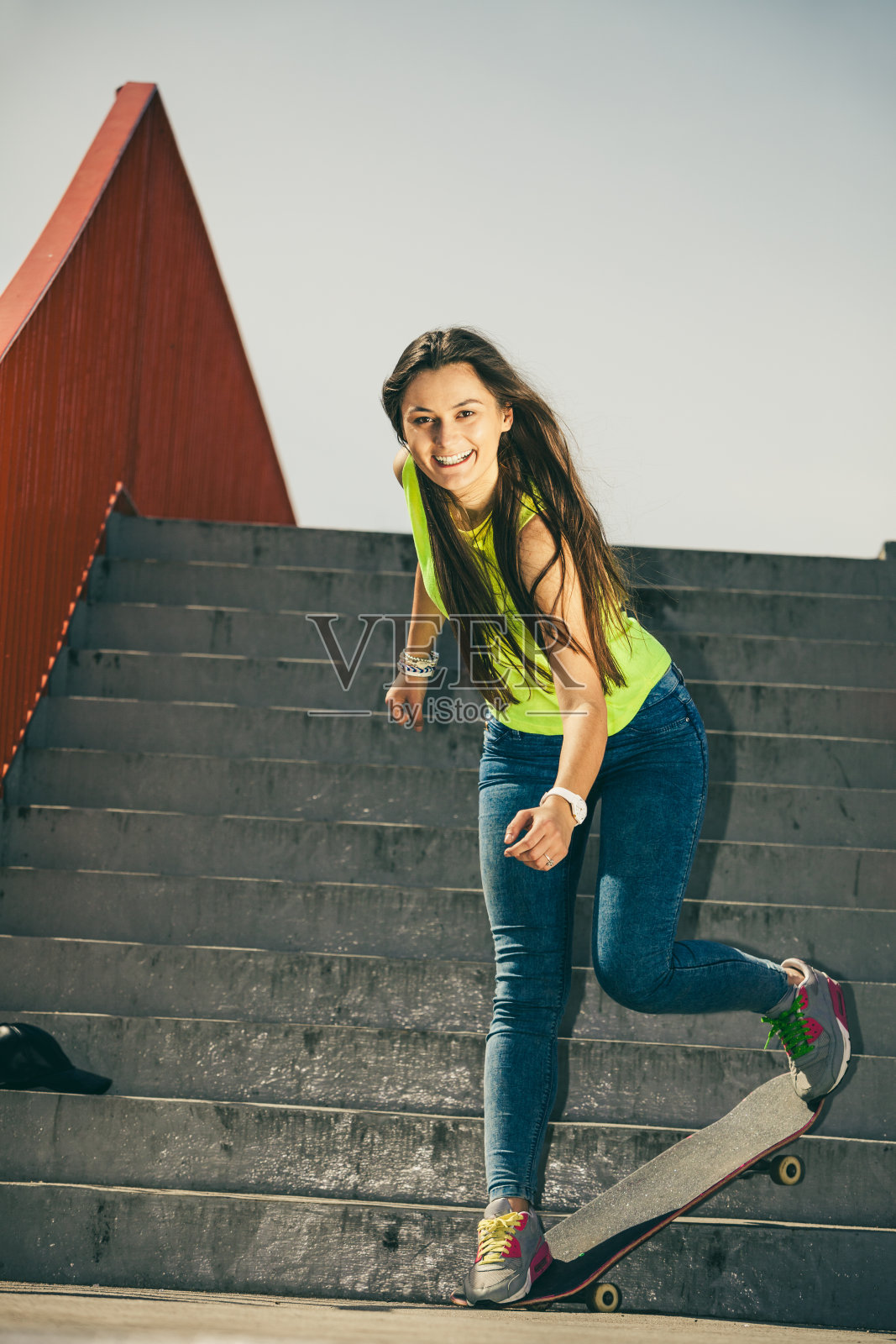 女孩在楼梯上玩滑板。照片摄影图片