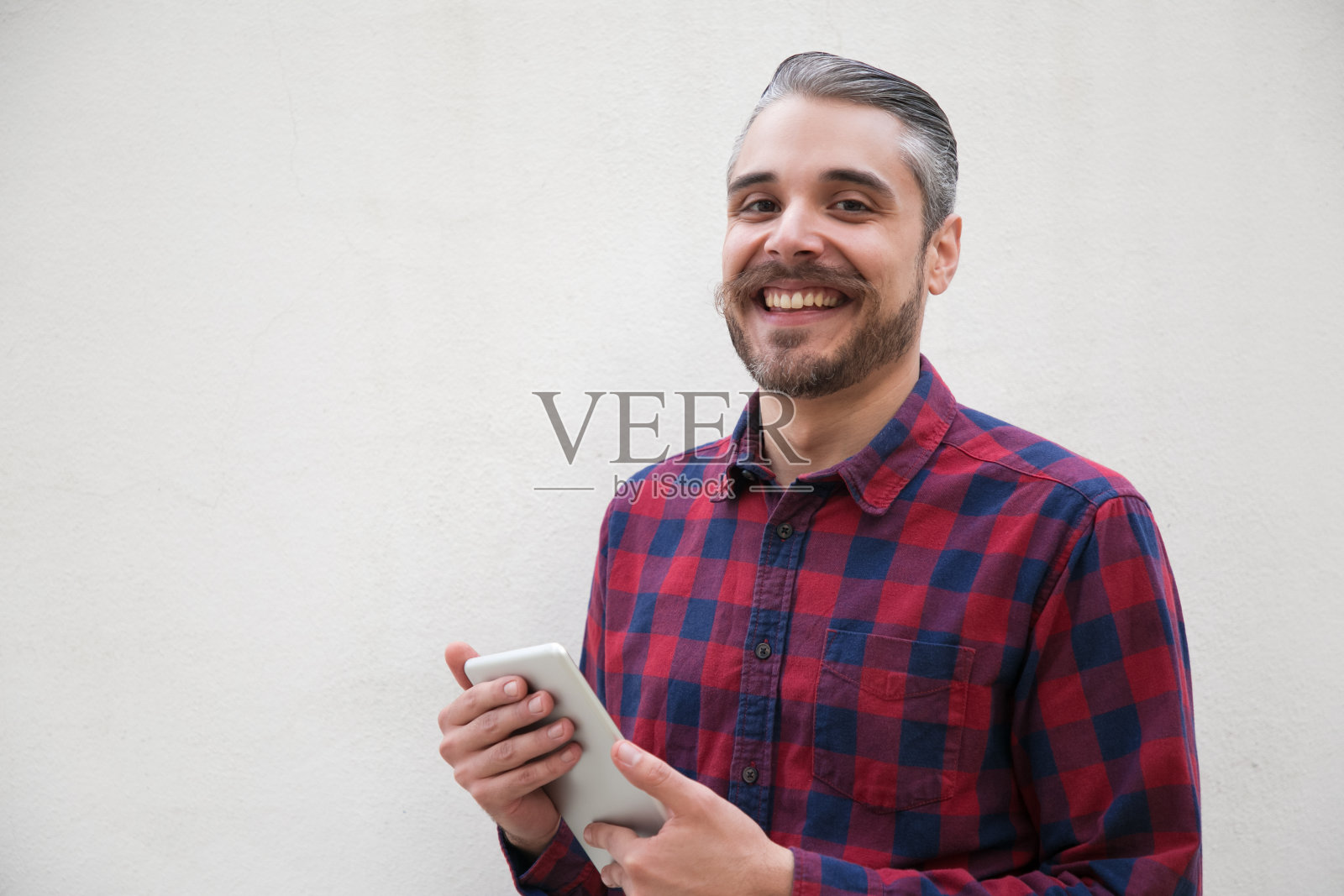 一个拿着数码平板电脑对着镜头微笑的快乐男人照片摄影图片