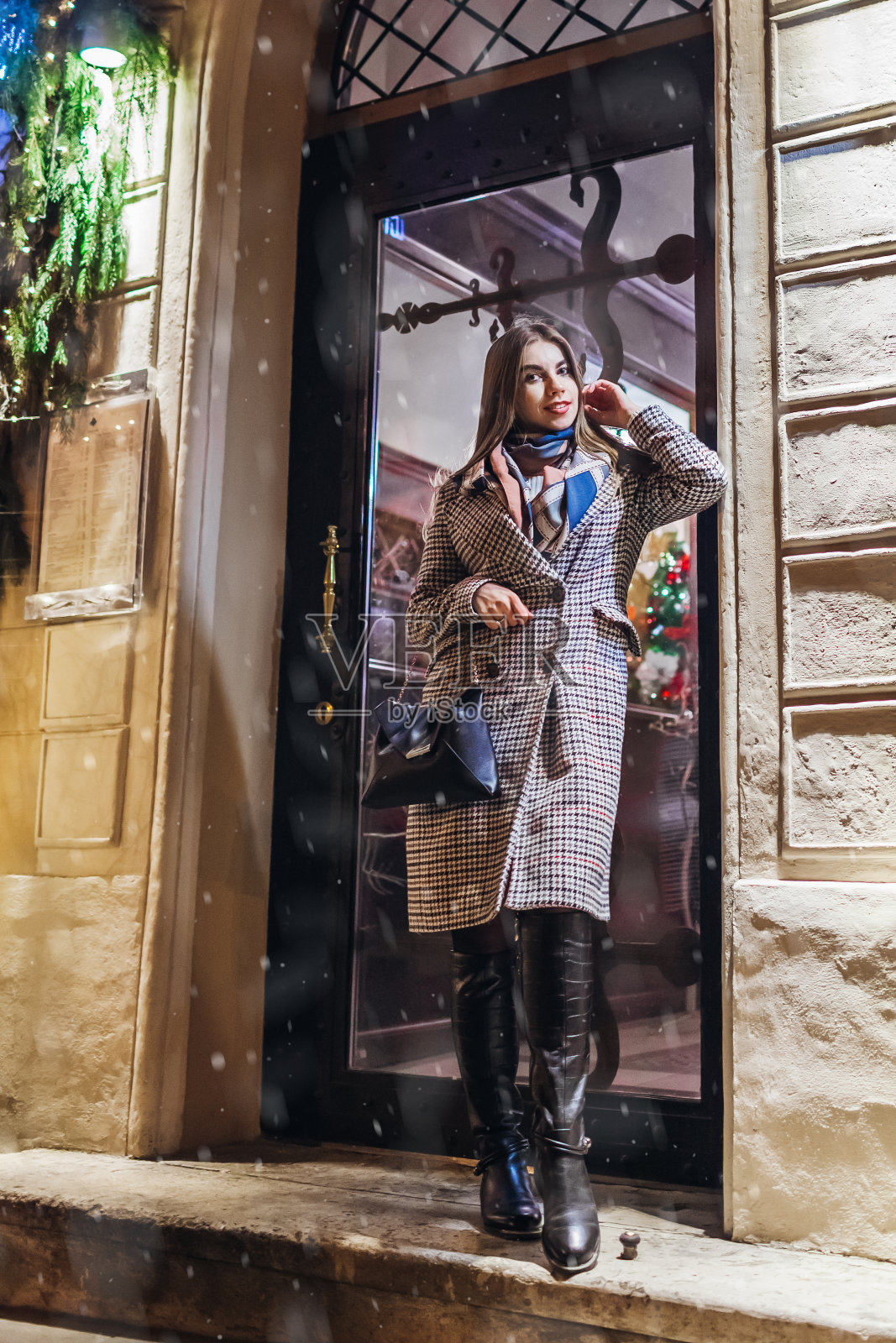 冬天的时尚。圣诞节，新年的概念。在城市街道上穿着时尚保暖的衣服和配饰的女人。照片摄影图片