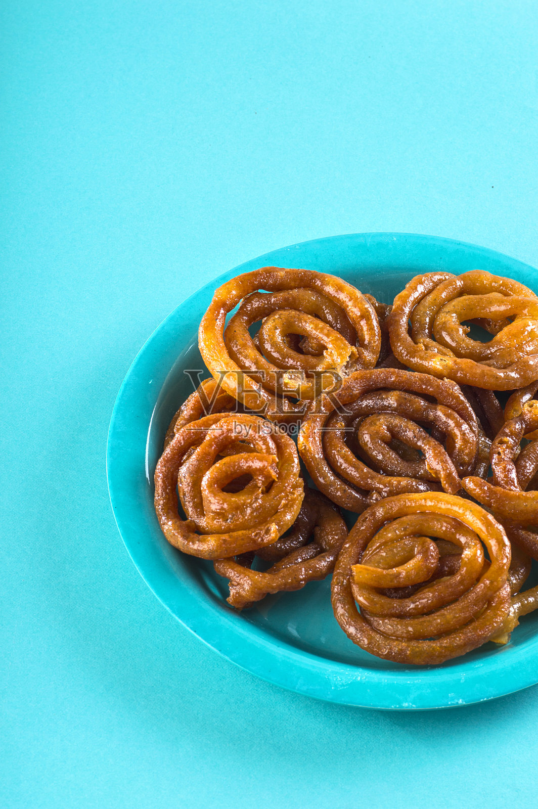 印度甜饼，印度甜饼，印度甜点，或imarti或imarati或jilbi在蓝色的背景照片摄影图片