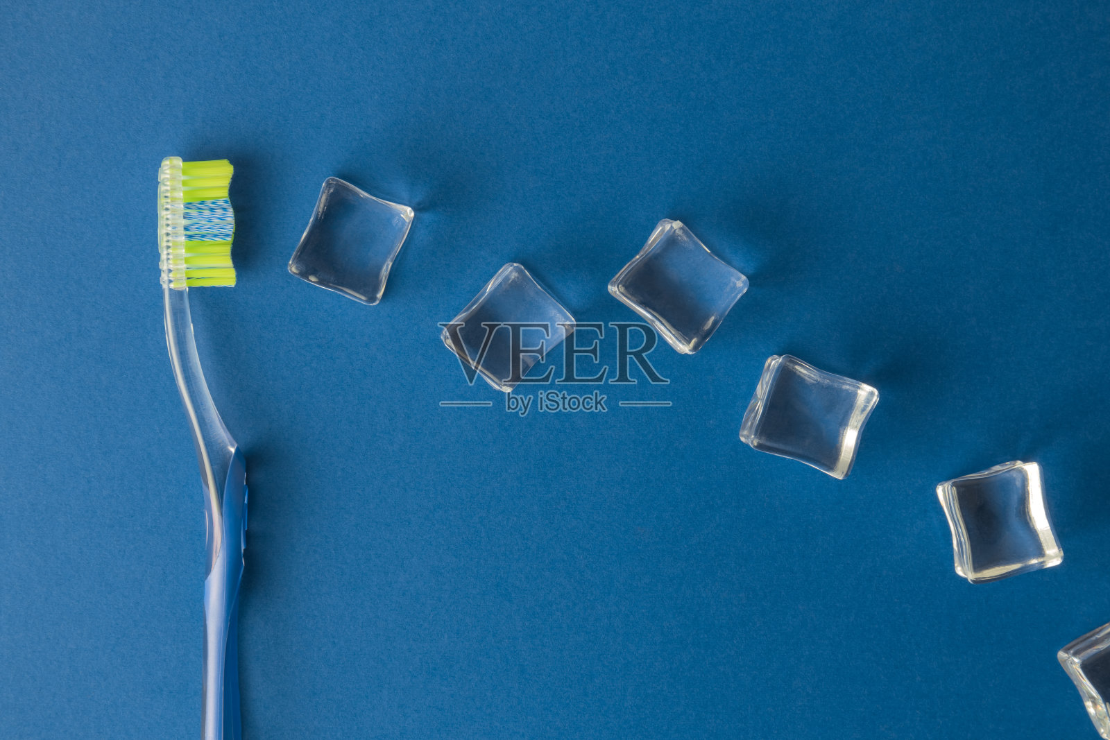 牙齿保健概念牙刷和冰块抽象在深蓝色。照片摄影图片