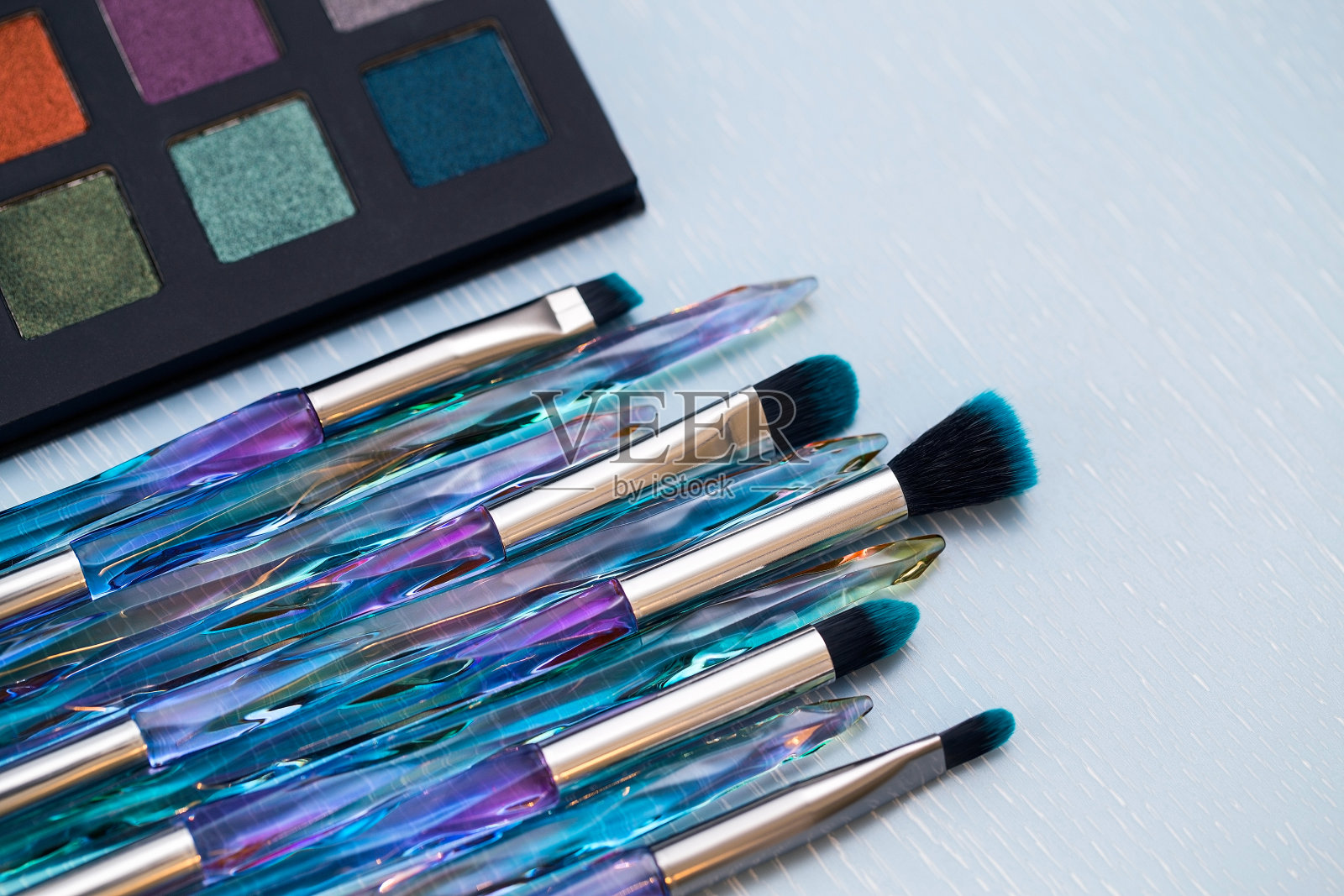 眼影刷，化妆品的素色背景，刷子和眼影调色板照片摄影图片