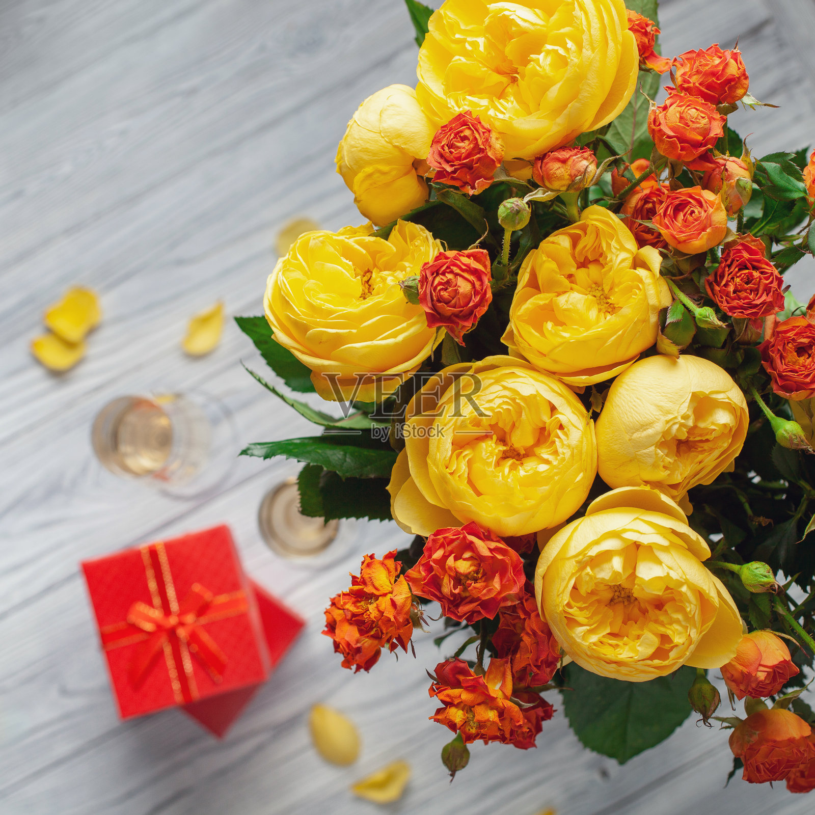 情人节概念与玫瑰花束和包装的礼物在木制桌子上，俯视图。平躺照片摄影图片