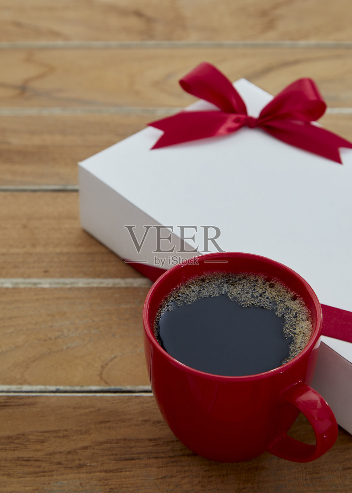 一个红杯咖啡和礼品盒在木制的复印空间。关闭了。情人节的背景。照片摄影图片