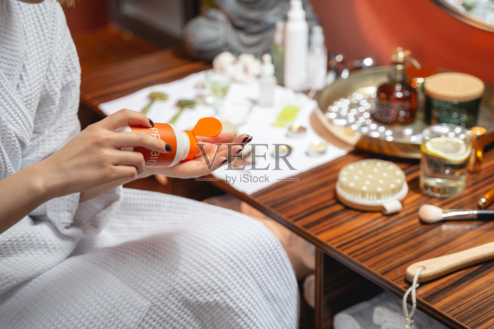 裁剪的照片，妇女在她的手上涂护手霜照片摄影图片