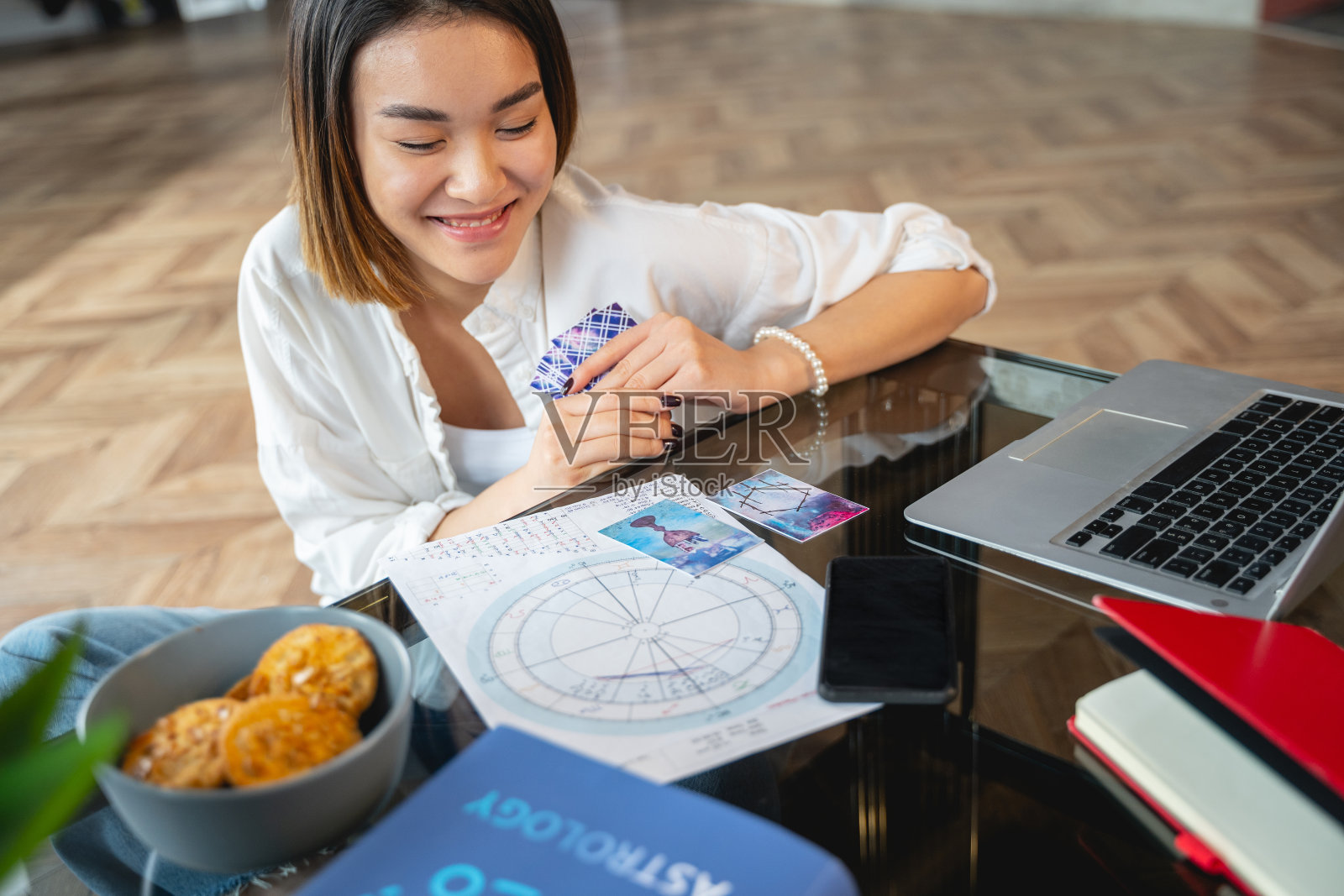 亚洲快乐女孩在室内分析她的星座照片摄影图片