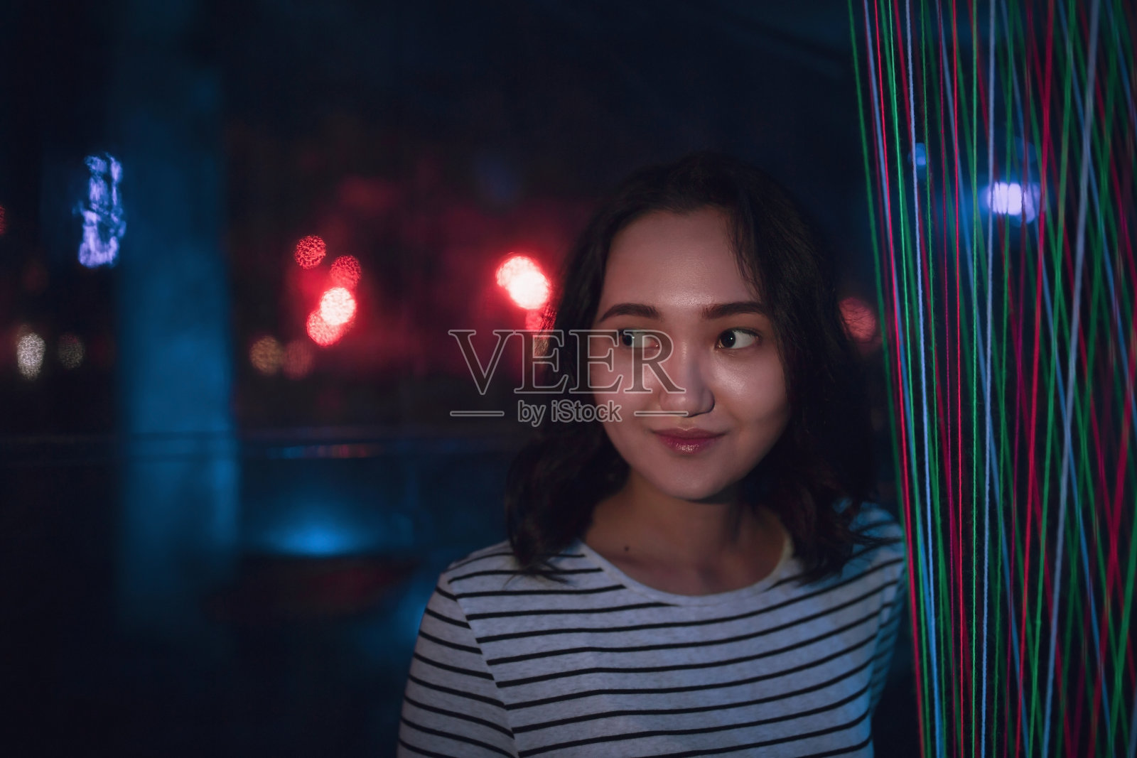 开朗乐观的亚洲女孩微笑着，霓虹灯背景照片摄影图片