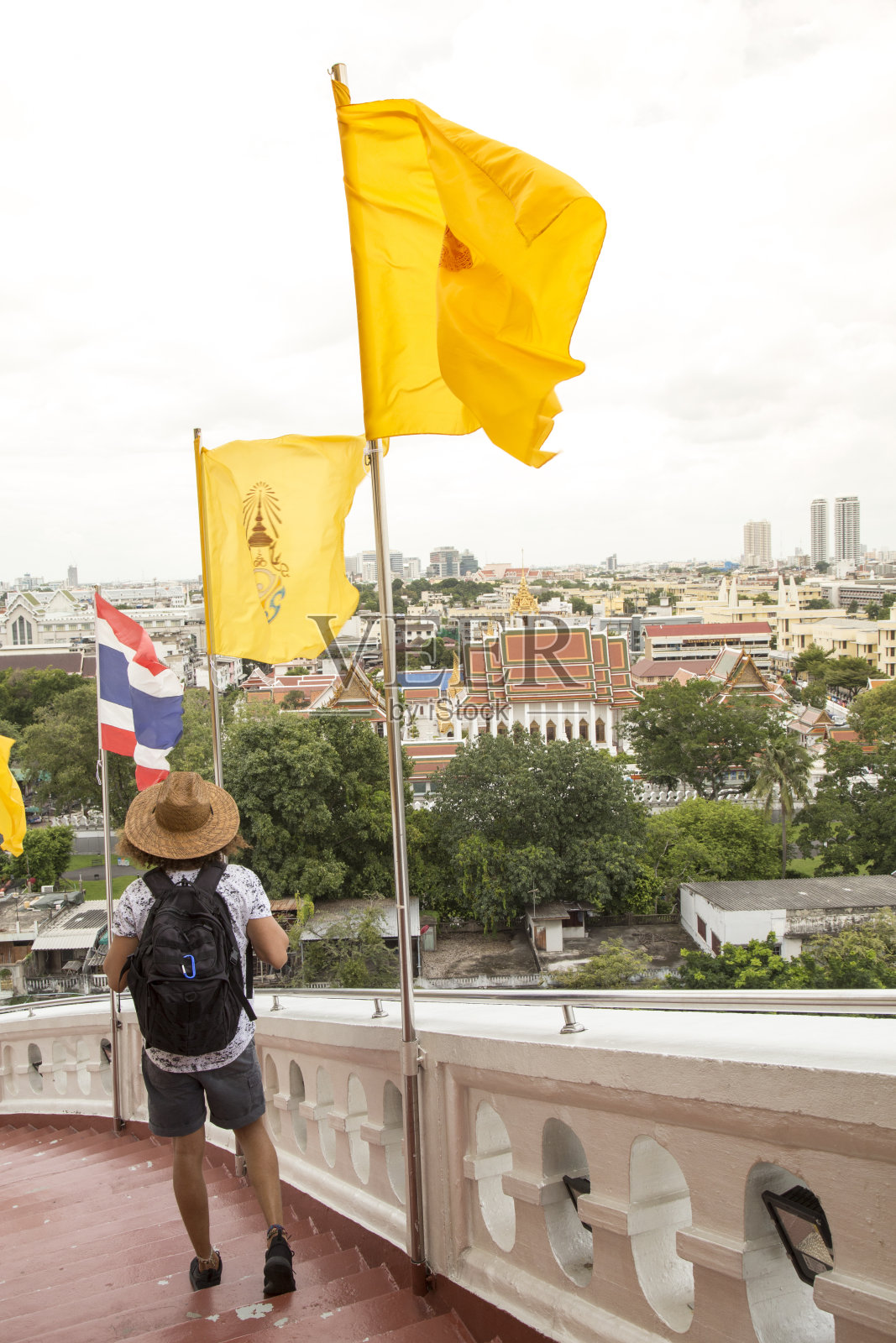 一位戴着太阳帽的年轻人，正走下曼谷萨吉寺的楼梯照片摄影图片