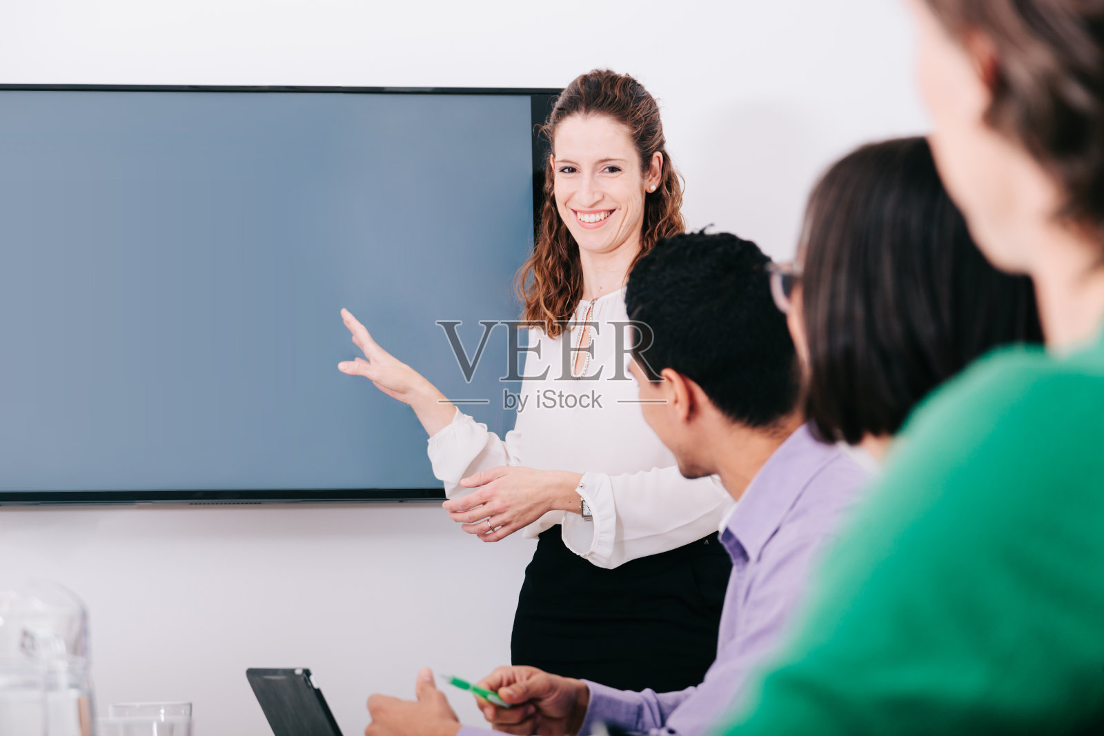 微笑女人在一次办公室会议上解释道照片摄影图片