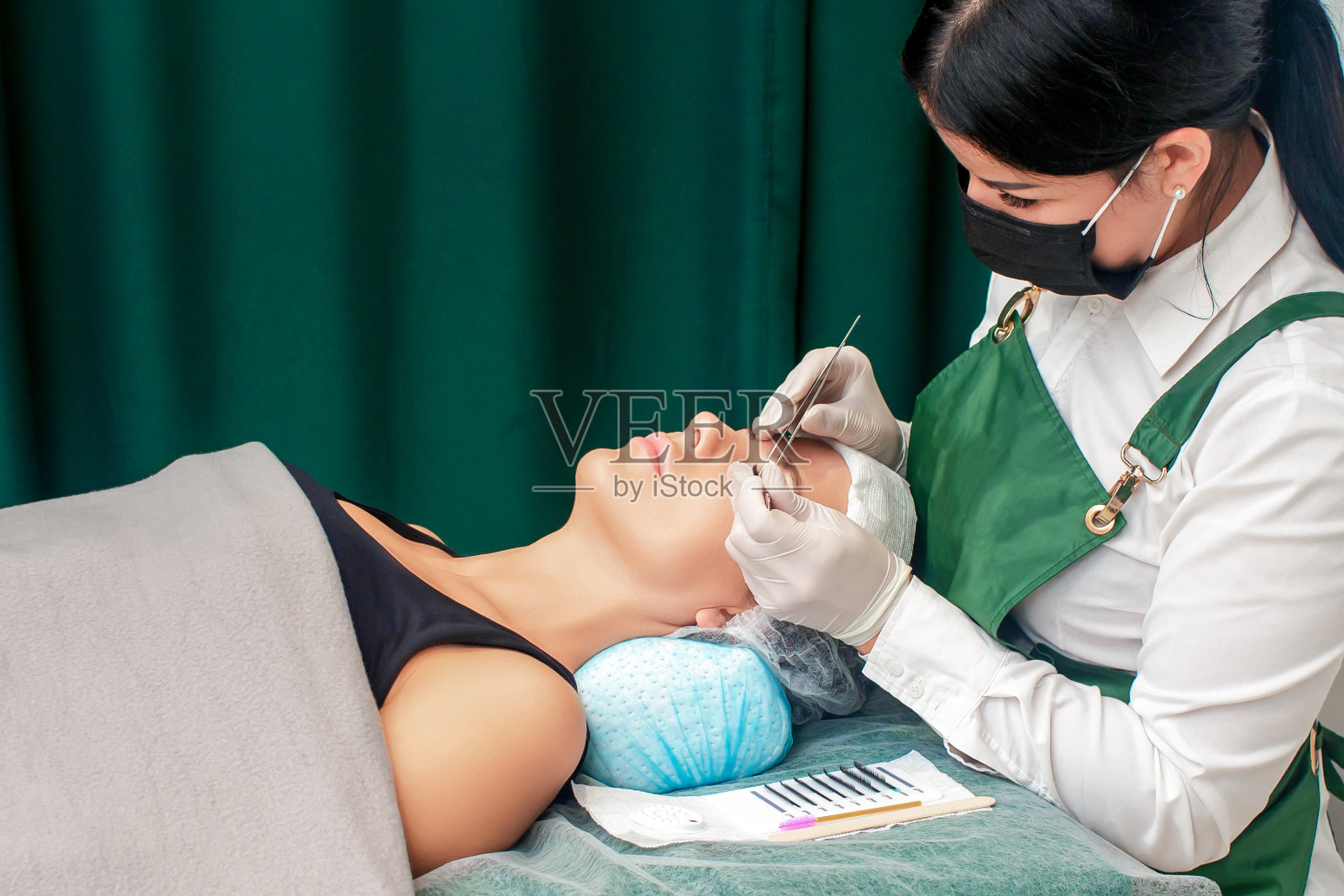 年轻女子接受睫毛延长。照片摄影图片