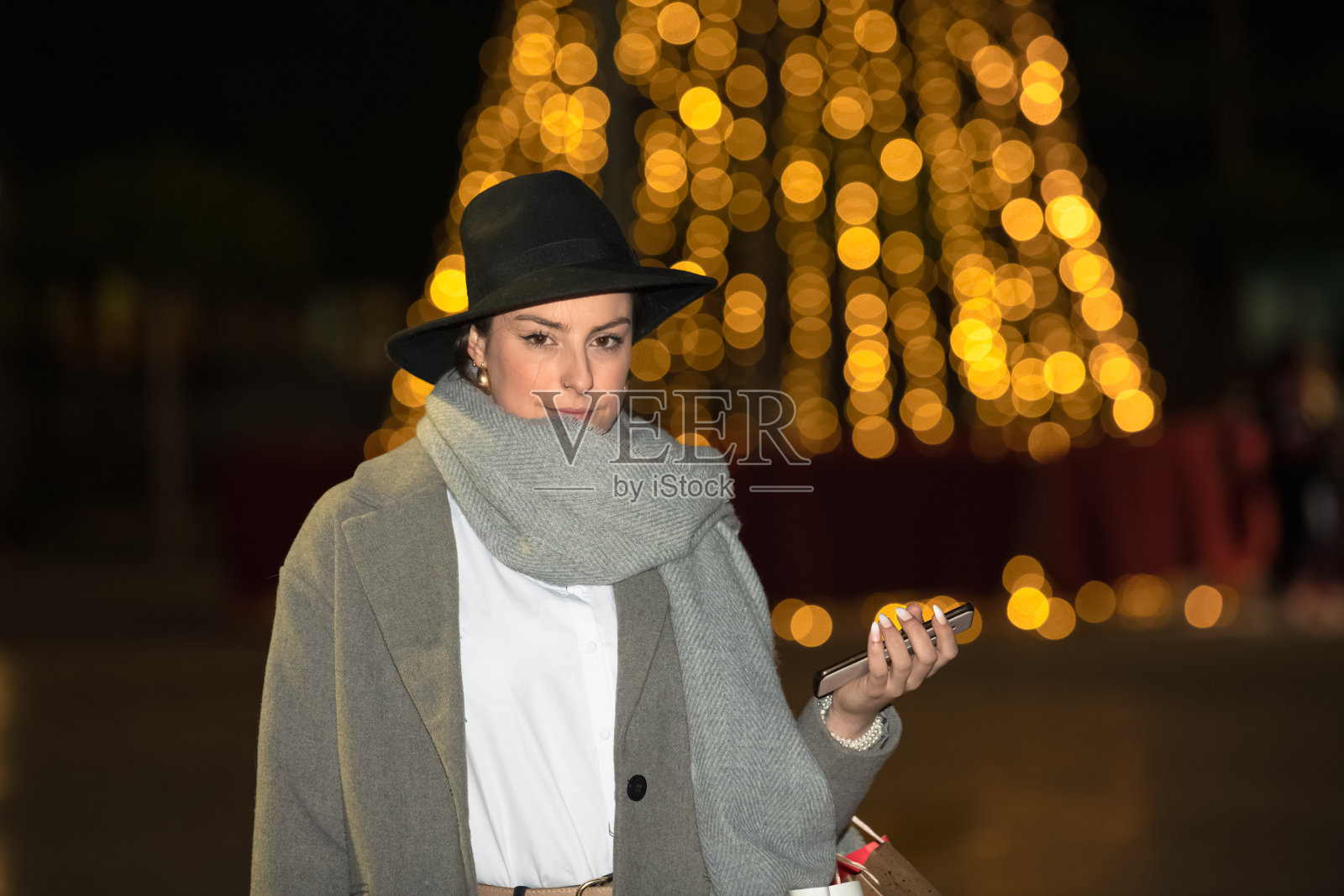 女人拿着手机看着相机照片摄影图片