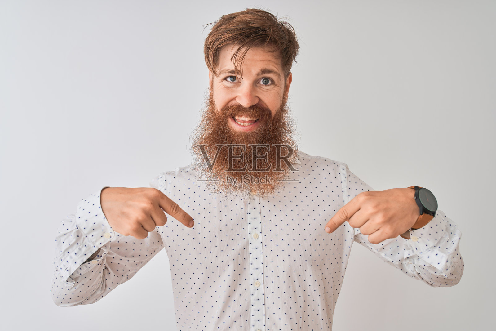 年轻的红发爱尔兰人穿着衬衫站在孤立的白色背景看起来自信的微笑在脸上，用手指指着自己骄傲和幸福。照片摄影图片