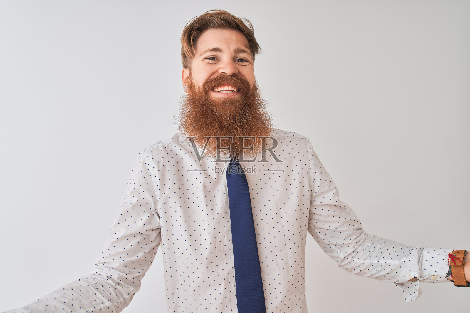 年轻的红头发爱尔兰商人站在孤立的白色背景，微笑着张开双臂，表示友好的欢迎，积极和自信的问候照片摄影图片