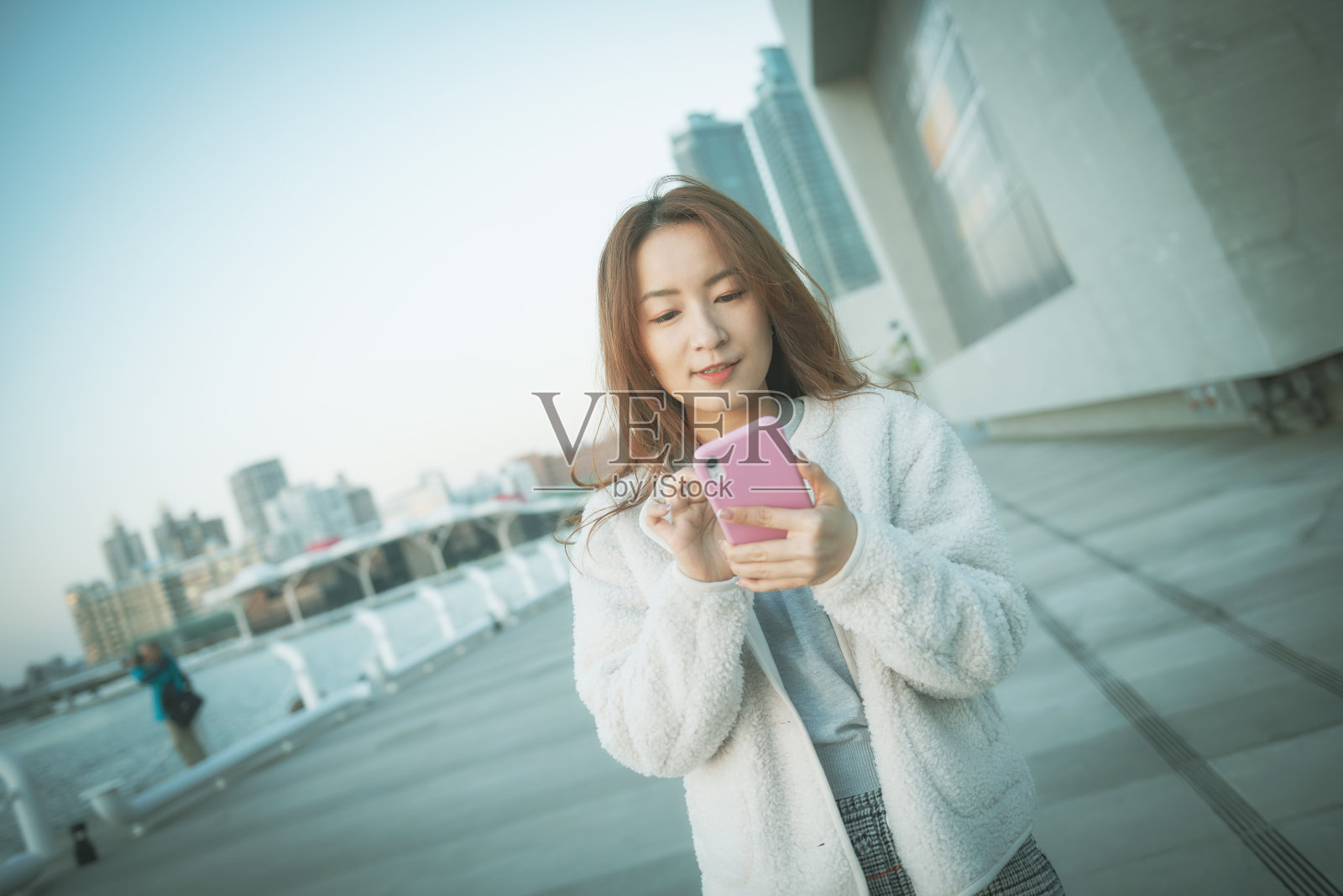 一名亚洲女性在公园里使用智能手机照片摄影图片