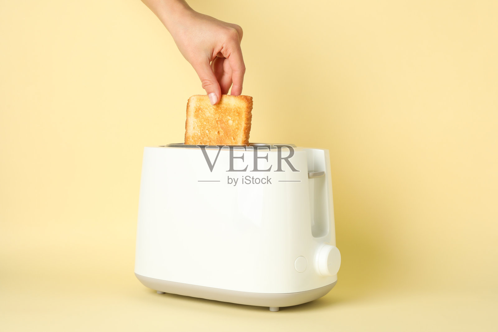 女性手把面包放在烤面包机米色背景，文字空间照片摄影图片