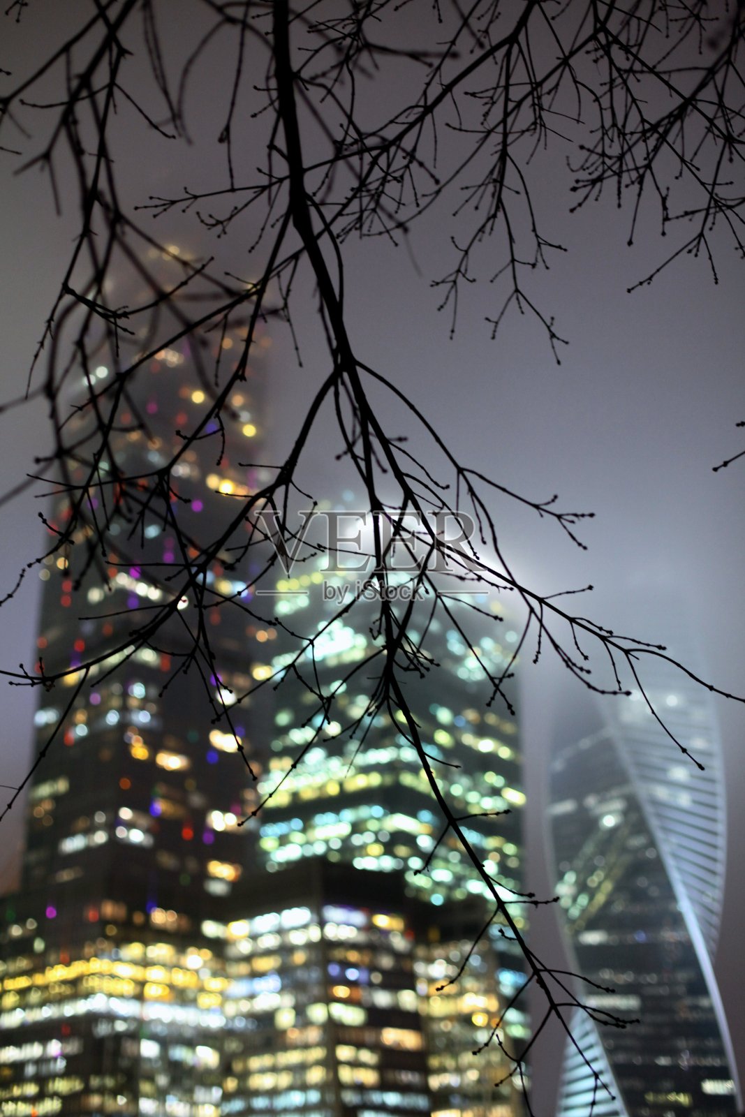 一个现代高层建筑在雾中的全景与霓虹灯在晚上。莫斯科城市照片摄影图片