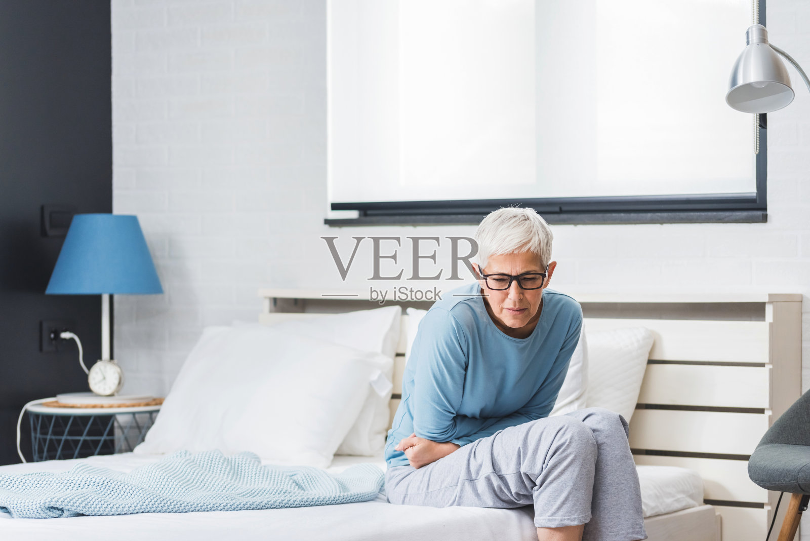 在家里饱受病痛折磨的资深女性照片摄影图片