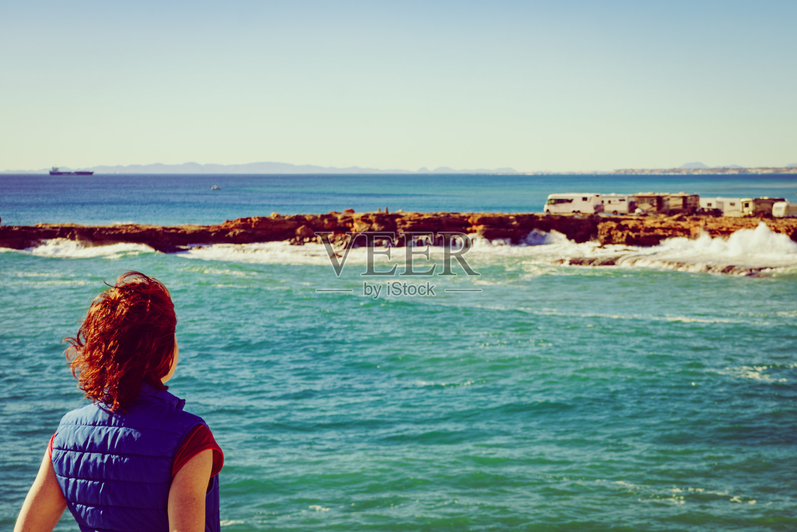 西班牙海边悬崖上的女游客照片摄影图片