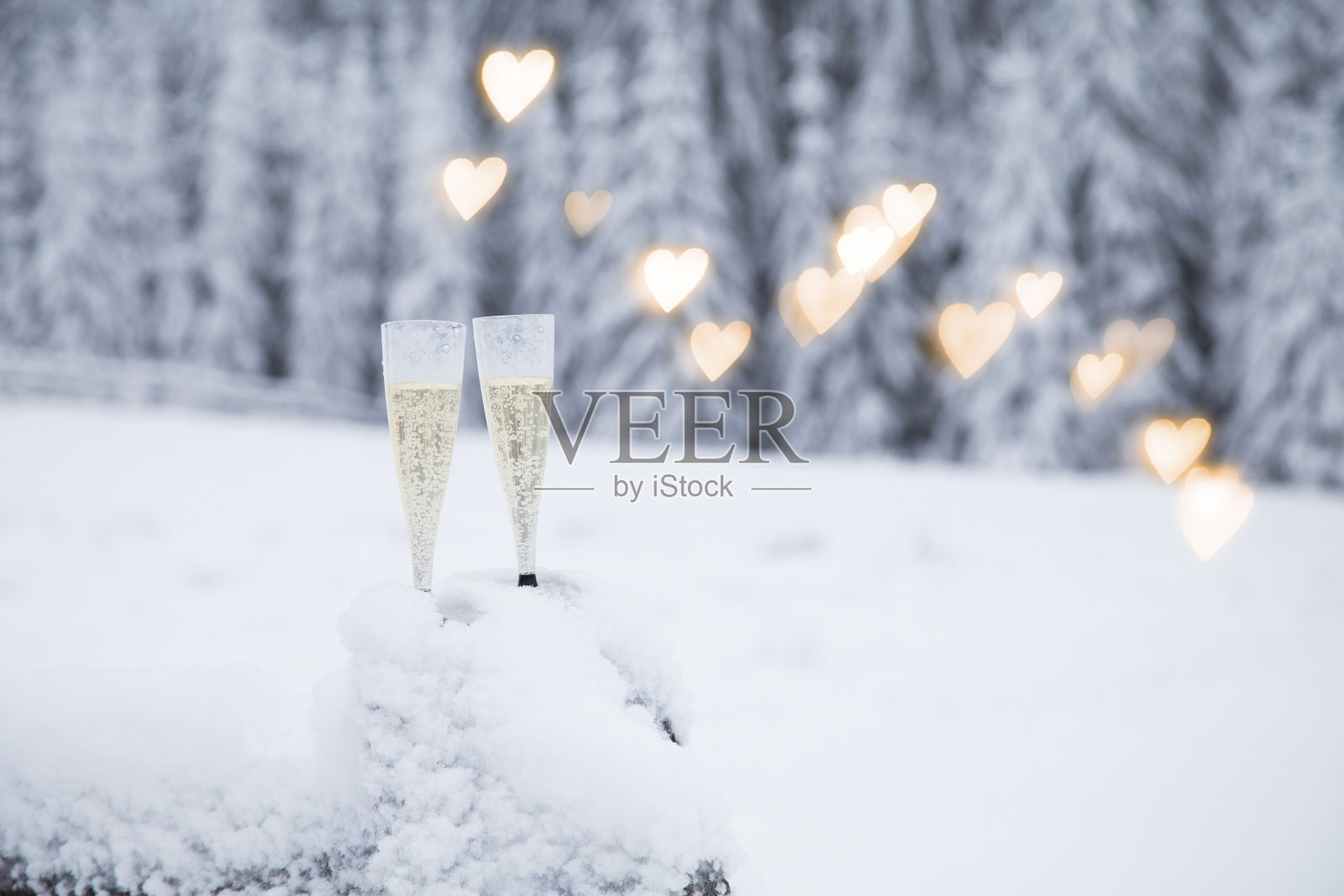 香槟酒杯在冬日仙境般的雪地里照片摄影图片