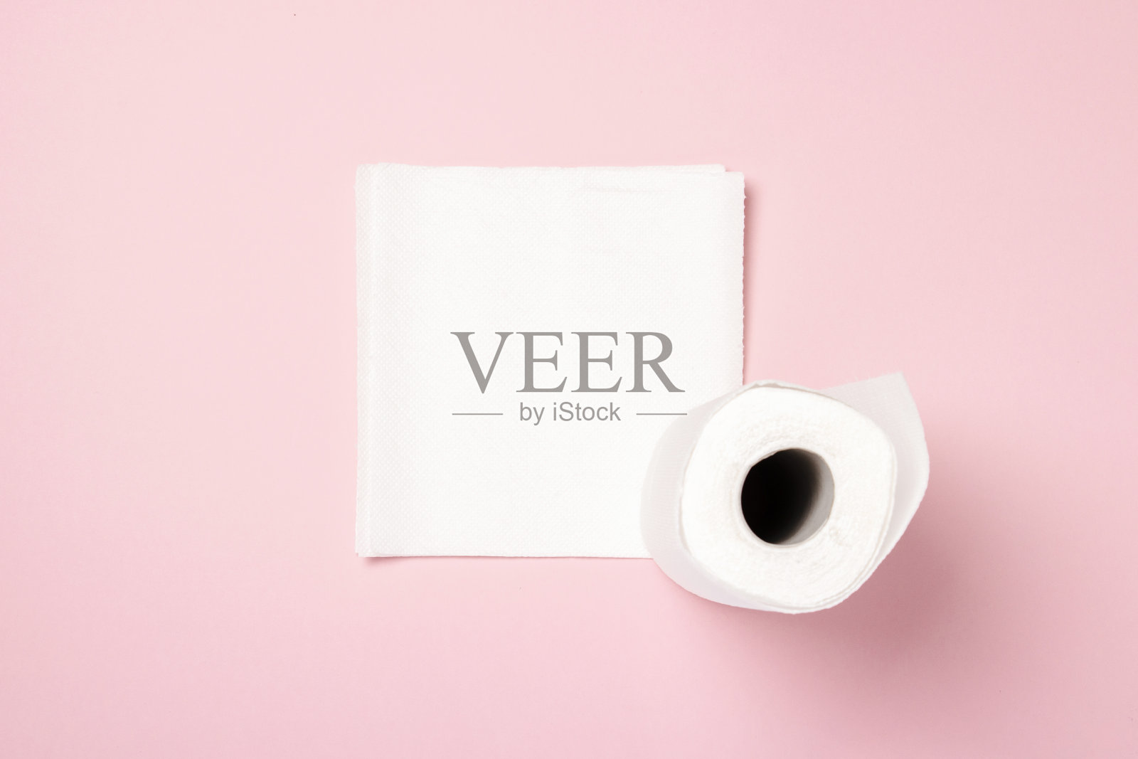 粉红色背景上的一卷纸巾。概念是100天然产品，精致柔软。平躺，俯视图。横幅照片摄影图片