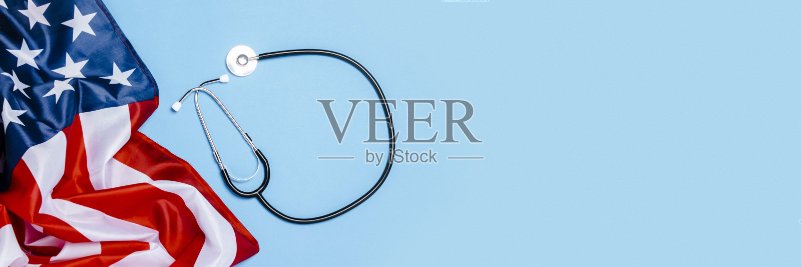 医生的听诊器和蓝色背景的美国国旗。美国医学理念，高水平，医疗保险，最好的药，疫苗，病毒，流行病。平躺，俯视图。横幅照片摄影图片