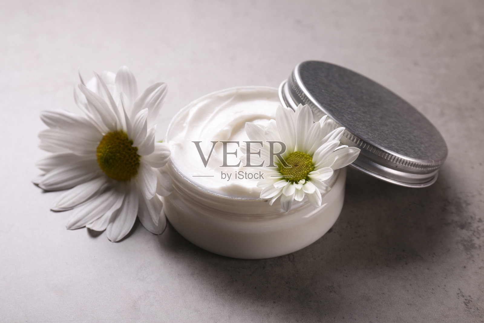 混凝土纹理背景与奶油罐和美丽的花朵组成。照片摄影图片