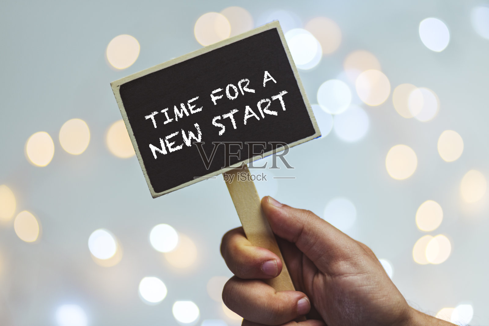 手握粉笔板与文字时间的一个新的开始，对抗轻散照片摄影图片