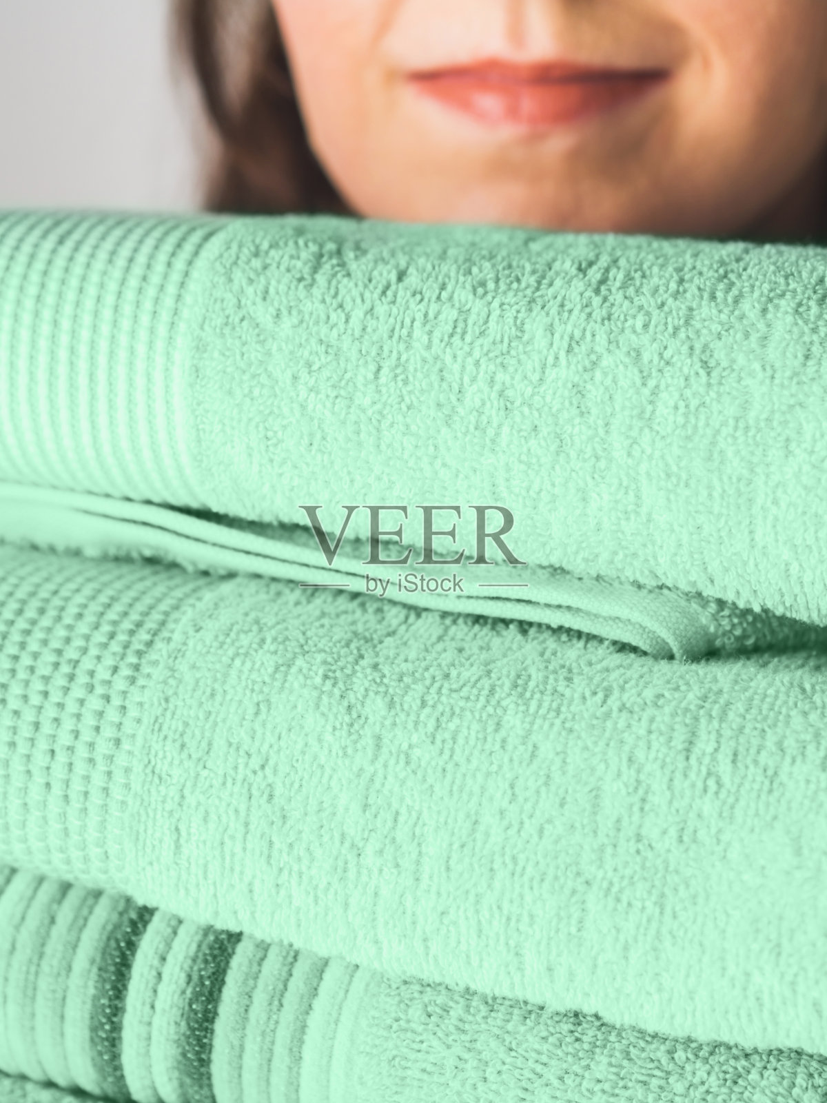 女人拿着干净的绿色薄荷折叠毛巾照片摄影图片