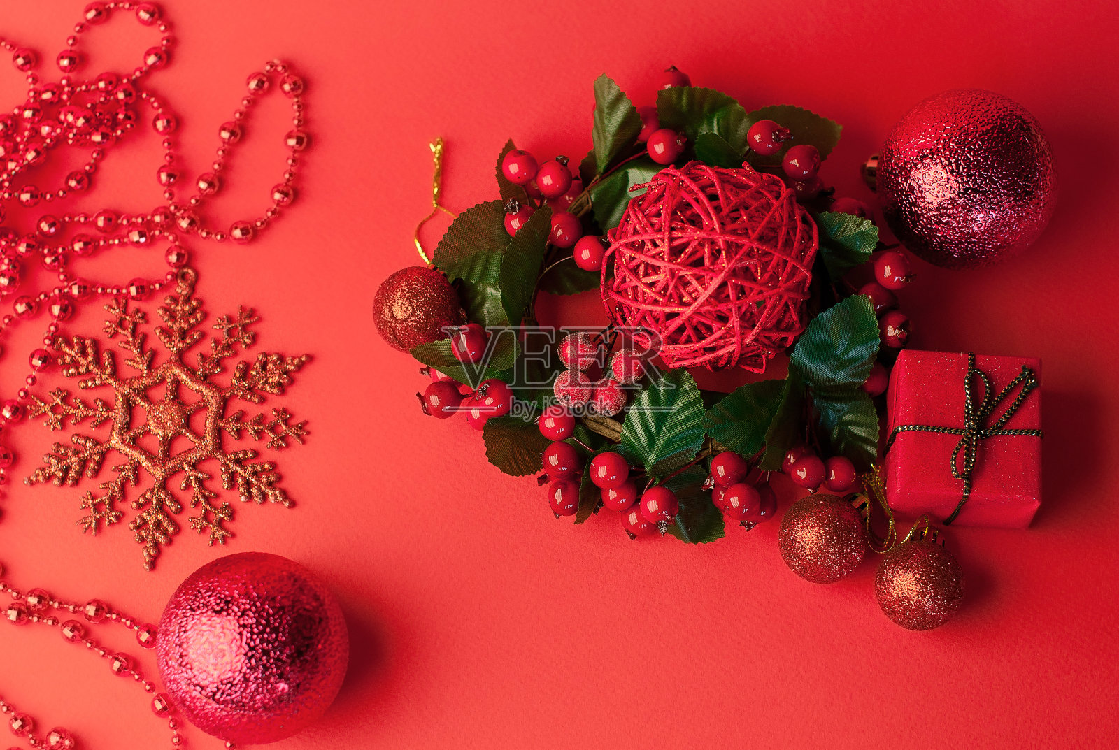 圣诞喜庆的红色背景与冷杉枝，下面是礼物在牛皮纸圣诞装饰品，玩具和雪花照片摄影图片