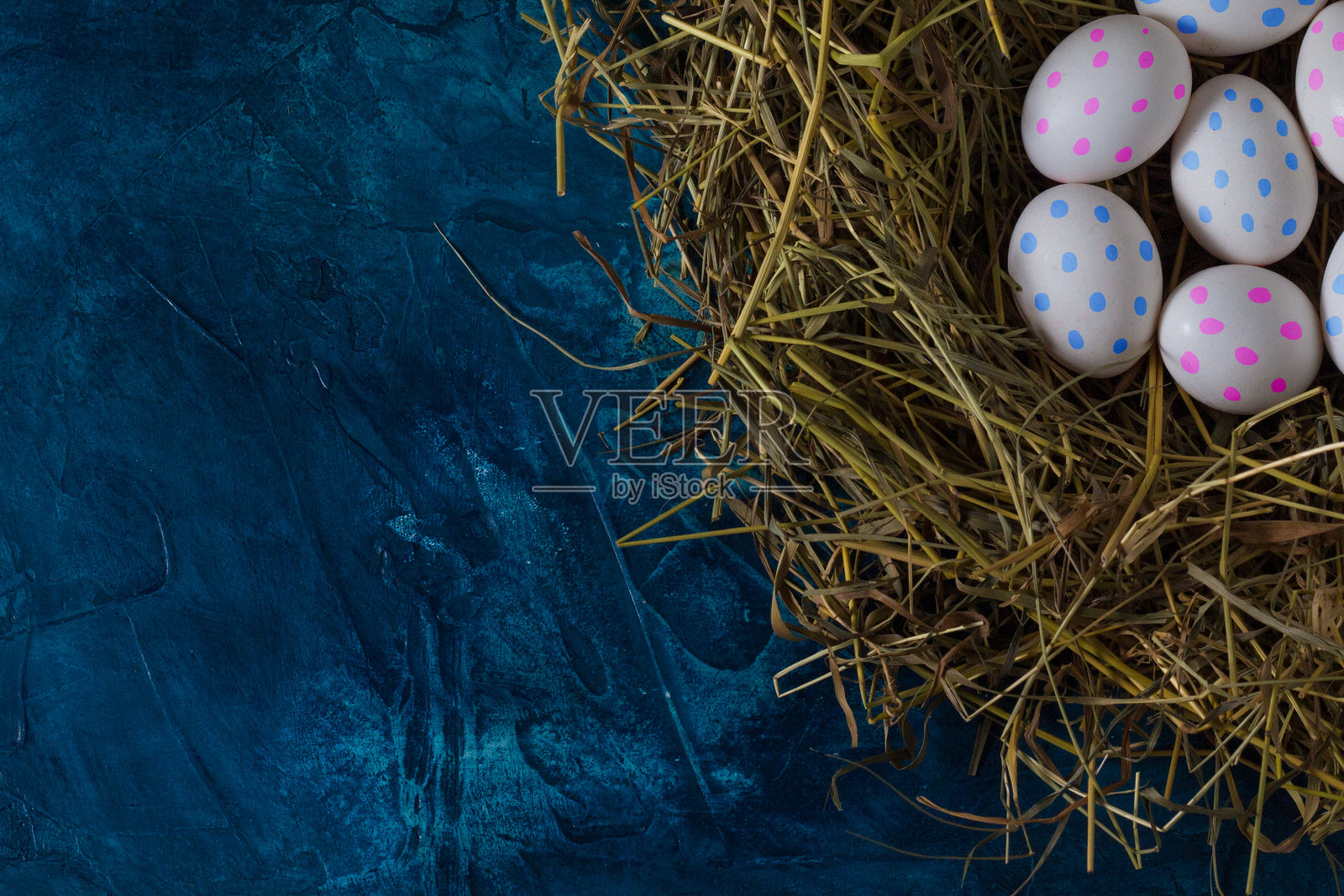 鸡复活节蛋在巢和白色织物上的蓝色背景。平躺，俯视图照片摄影图片