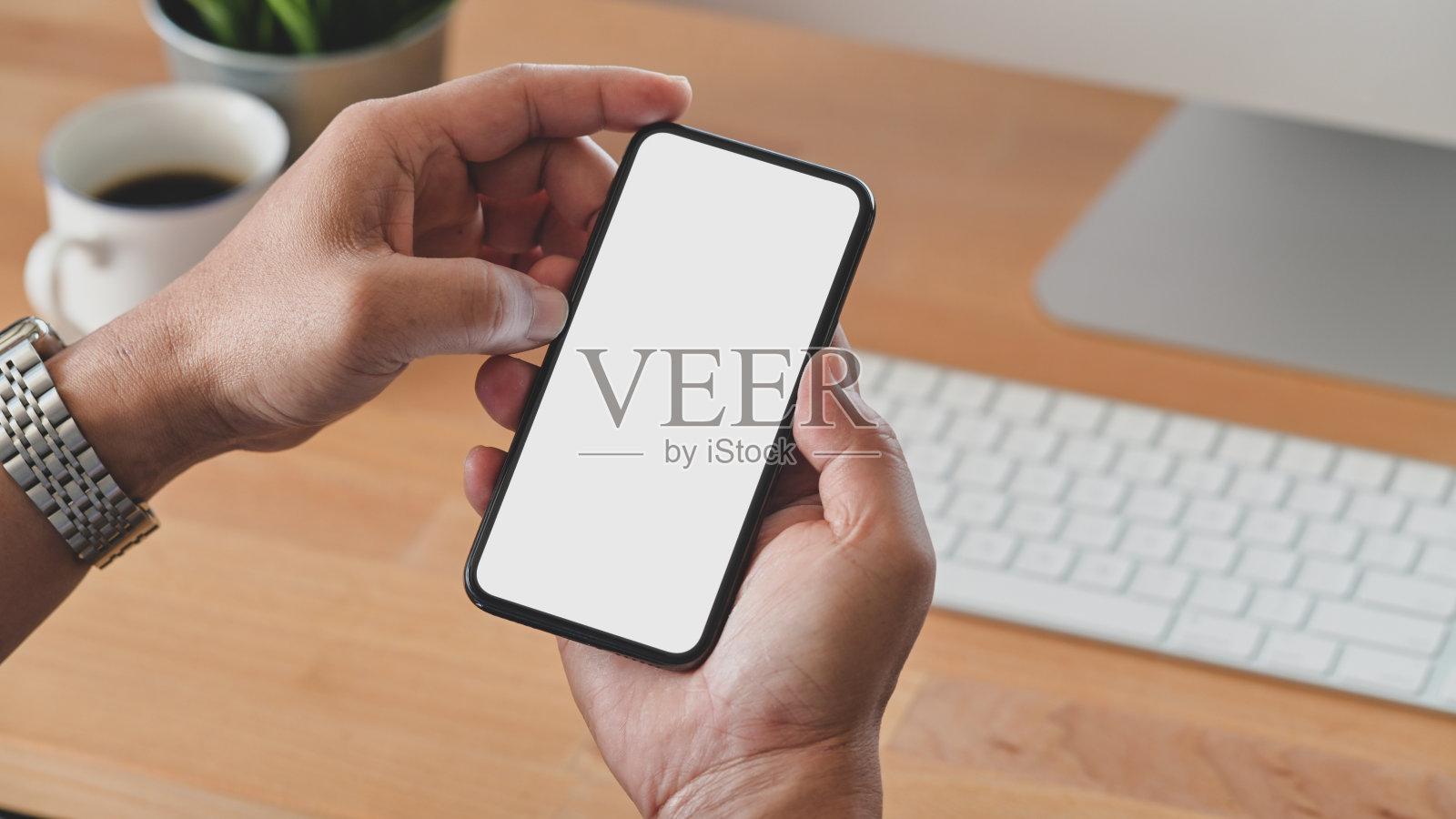 年轻男子手持空白屏幕智能手机的剪影照片摄影图片