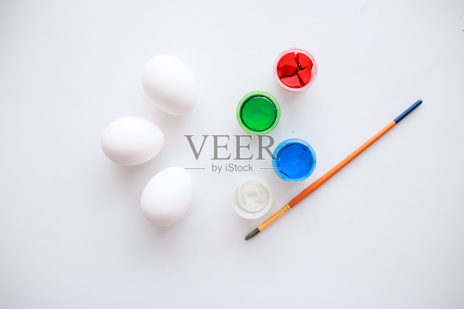 白色木制背景上的复活节彩蛋。鲜花和糖果。照片摄影图片