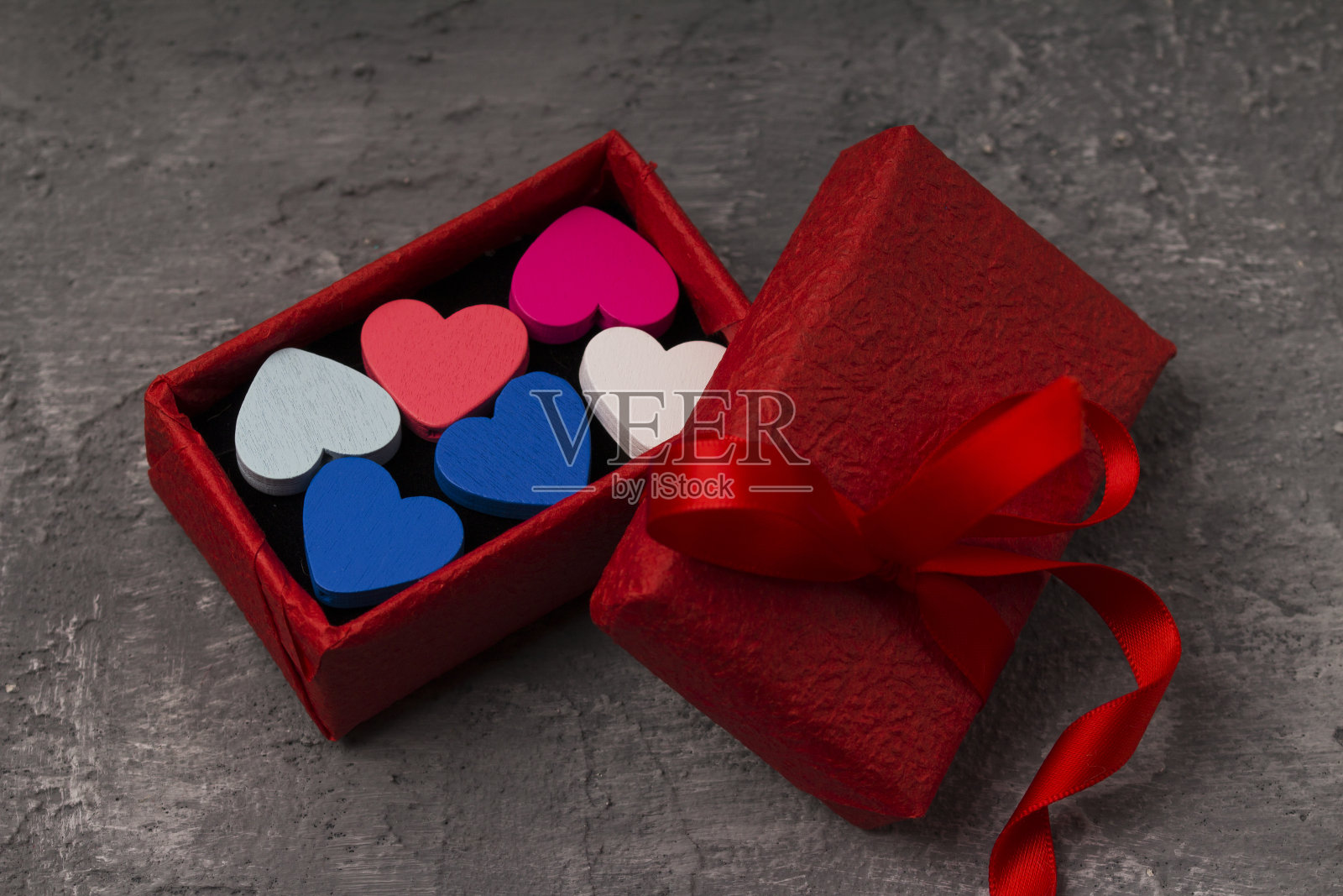 情人节背景与心和一个红色的礼物盒在混凝土板与复制空间。照片摄影图片