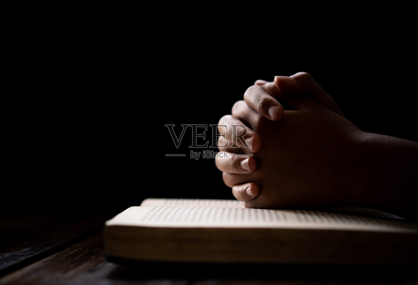 手妇女放置在圣经，同时祈祷基督教的祝福和祈祷上帝照片摄影图片