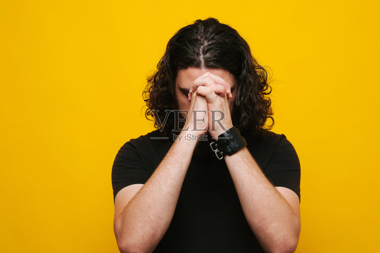 长头发的男人正在祈祷照片摄影图片