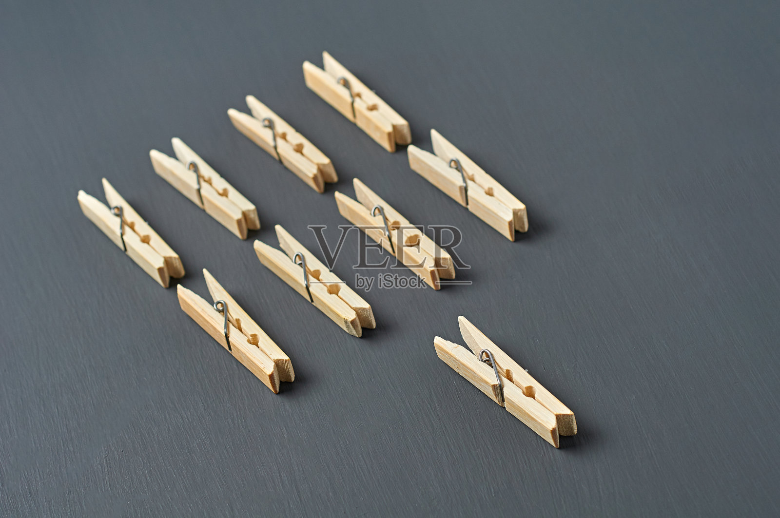 浴室里深色的混凝土桌子上放着一排排木制晾衣夹。特写镜头照片摄影图片