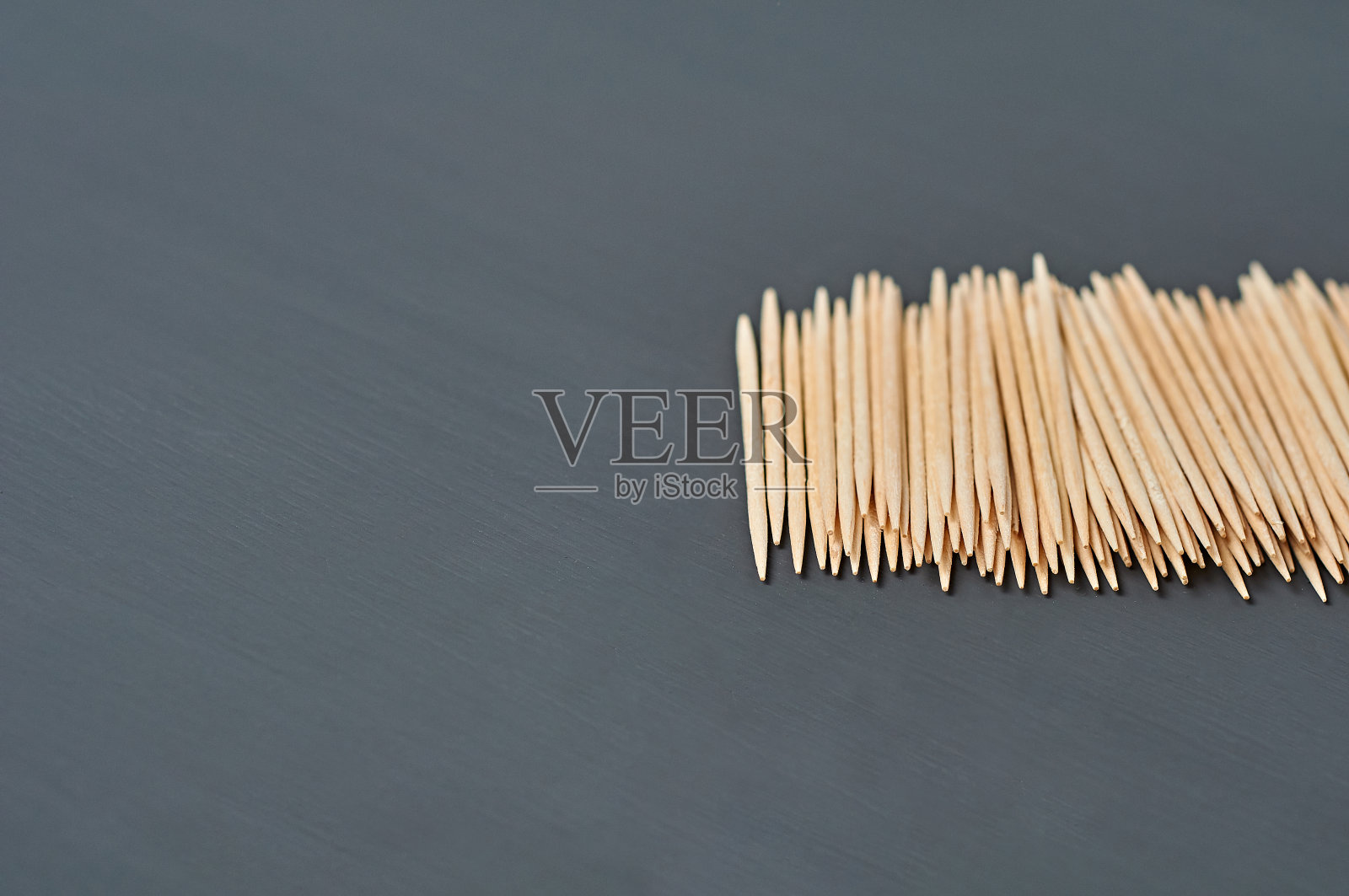 厨房黑色的水泥桌上放着一排木制牙签。空间的文本照片摄影图片