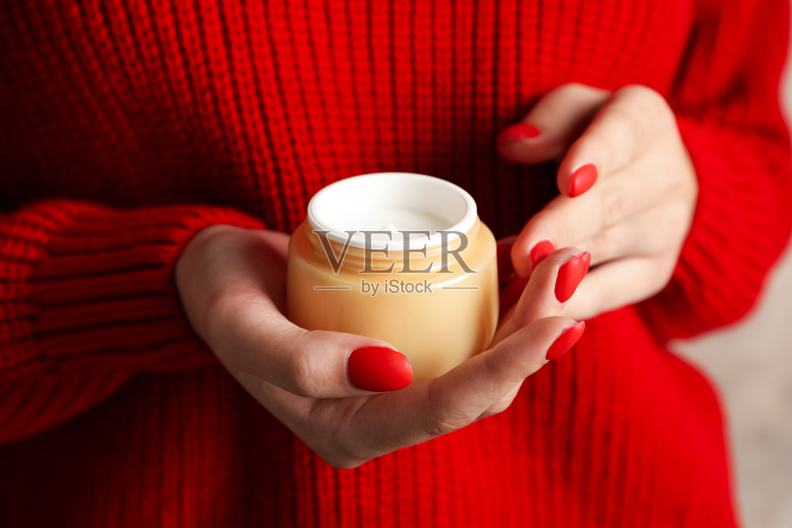 女人拿着一瓶保湿霜，特写。冬天的化妆品。空间的文本照片摄影图片