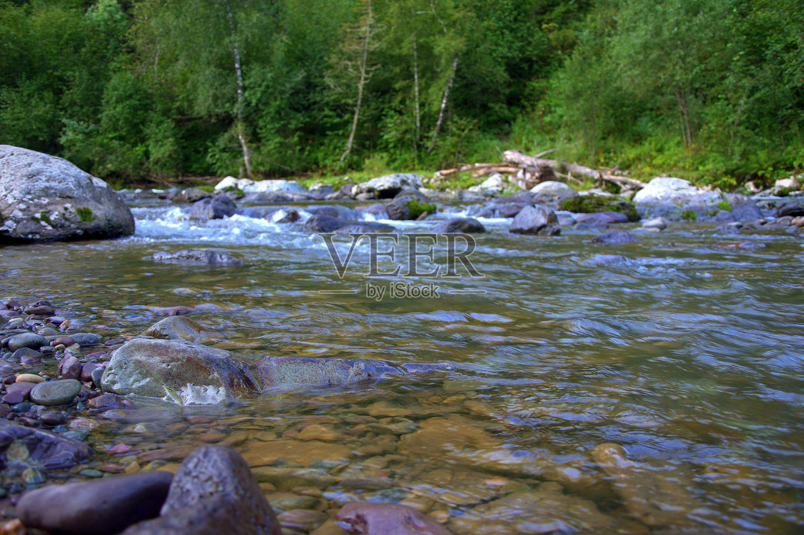 一条湍急湍急的山河的碎片，一路上包裹着巨大的巨石。照片摄影图片