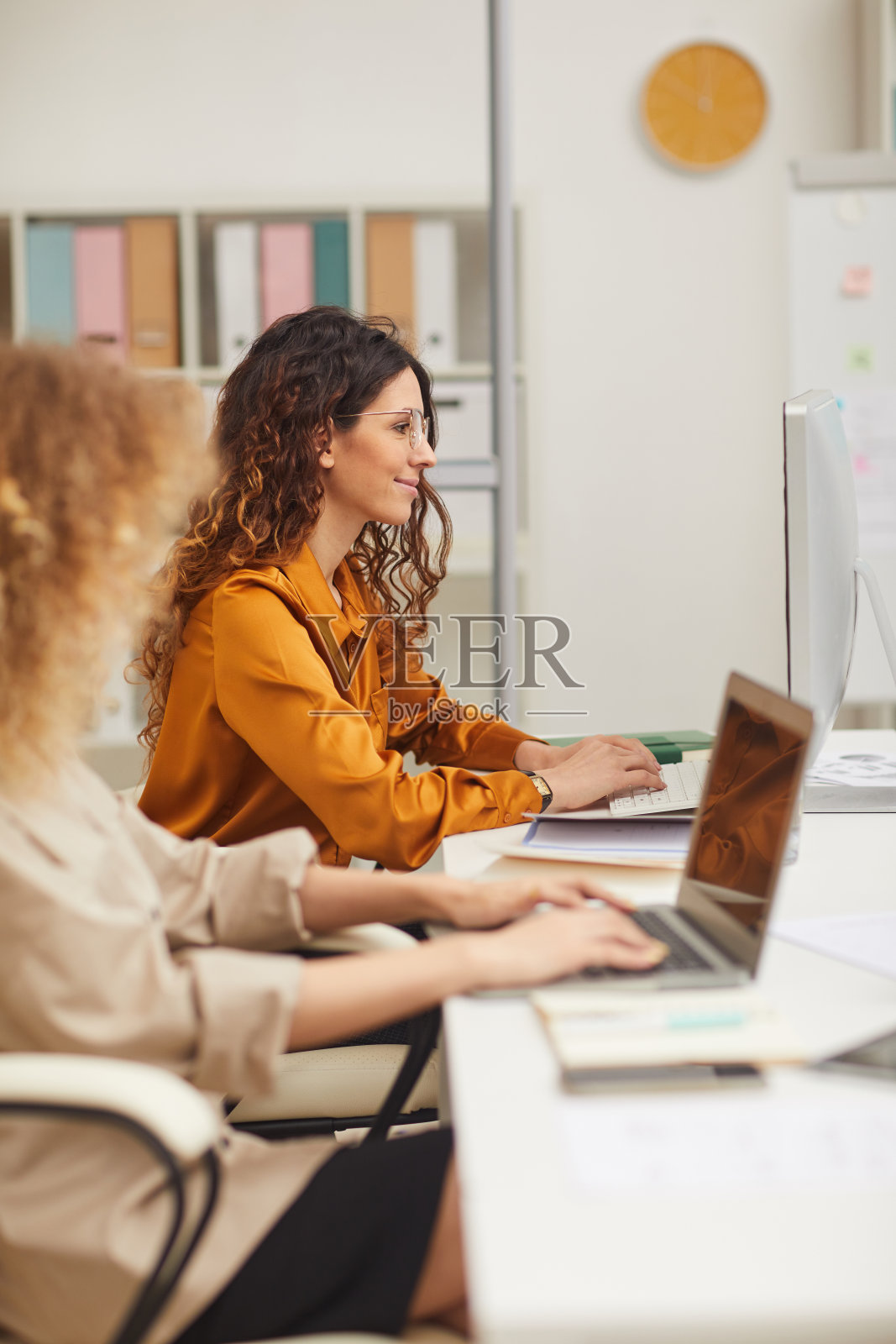 两个在电脑上工作的年轻女商人照片摄影图片