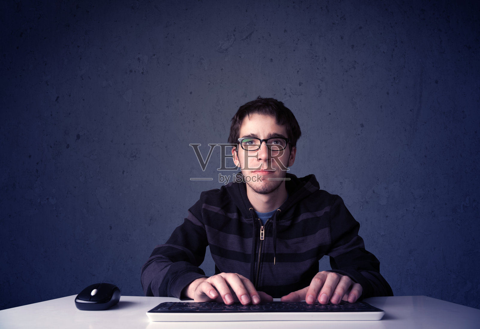 在蓝色背景上使用键盘工作的黑客照片摄影图片