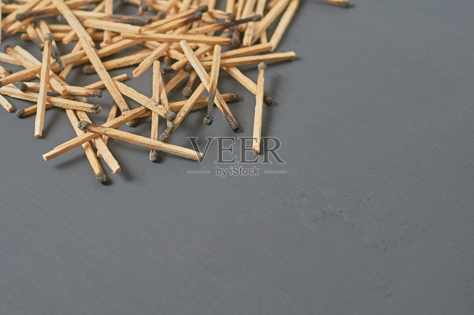 厨房里深色的混凝土桌子上散落着许多用过的、烧过硫磺的火柴棍。空间的文本照片摄影图片