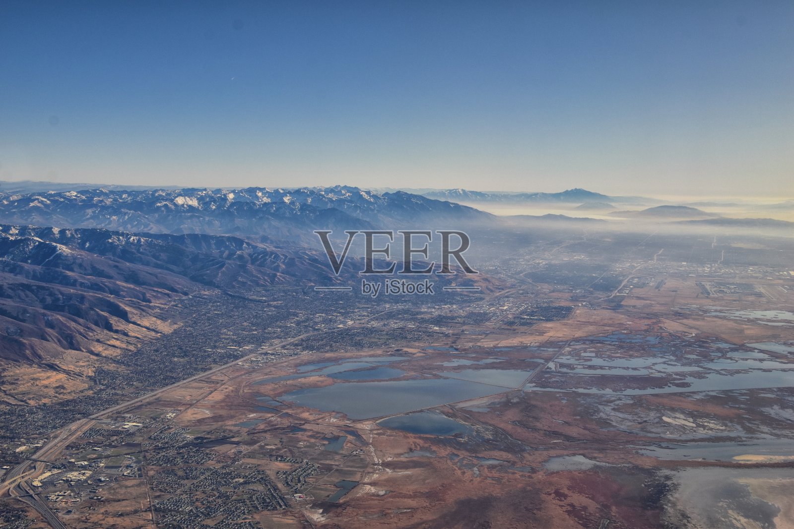 美国犹他州盐湖城周围的城市和大盐湖在秋天从飞机上鸟瞰的瓦萨奇前落基山脉。美国。照片摄影图片