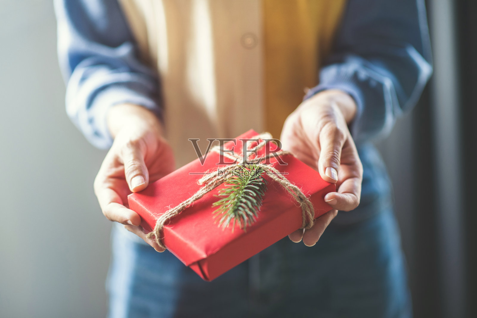 女人手捧牛皮纸礼品盒，作为圣诞和新年假期的礼物。照片摄影图片
