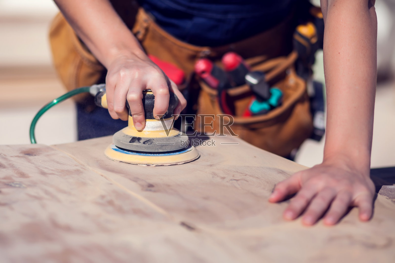 用砂纸打磨木质表面的年轻利索女子照片摄影图片