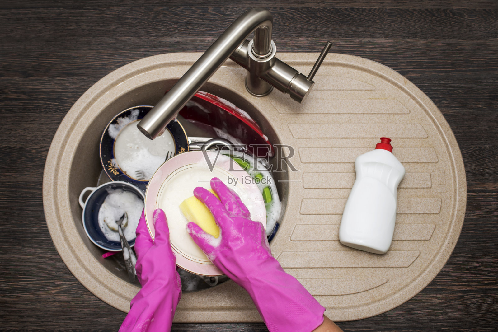 在厨房里洗盘子的女人。女人的手的特写。家庭主妇干净的盘子。在厨房做家务。照片摄影图片