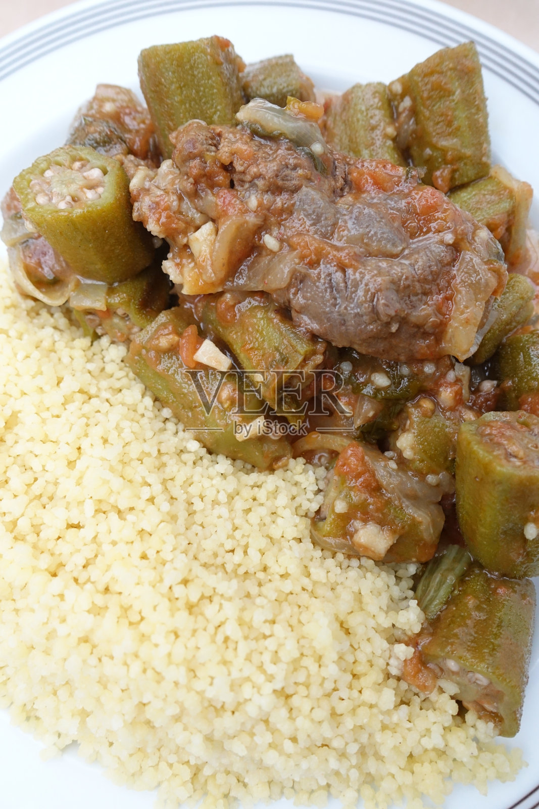 秋葵炖牛肉和蒸粗麦粉一起食用照片摄影图片