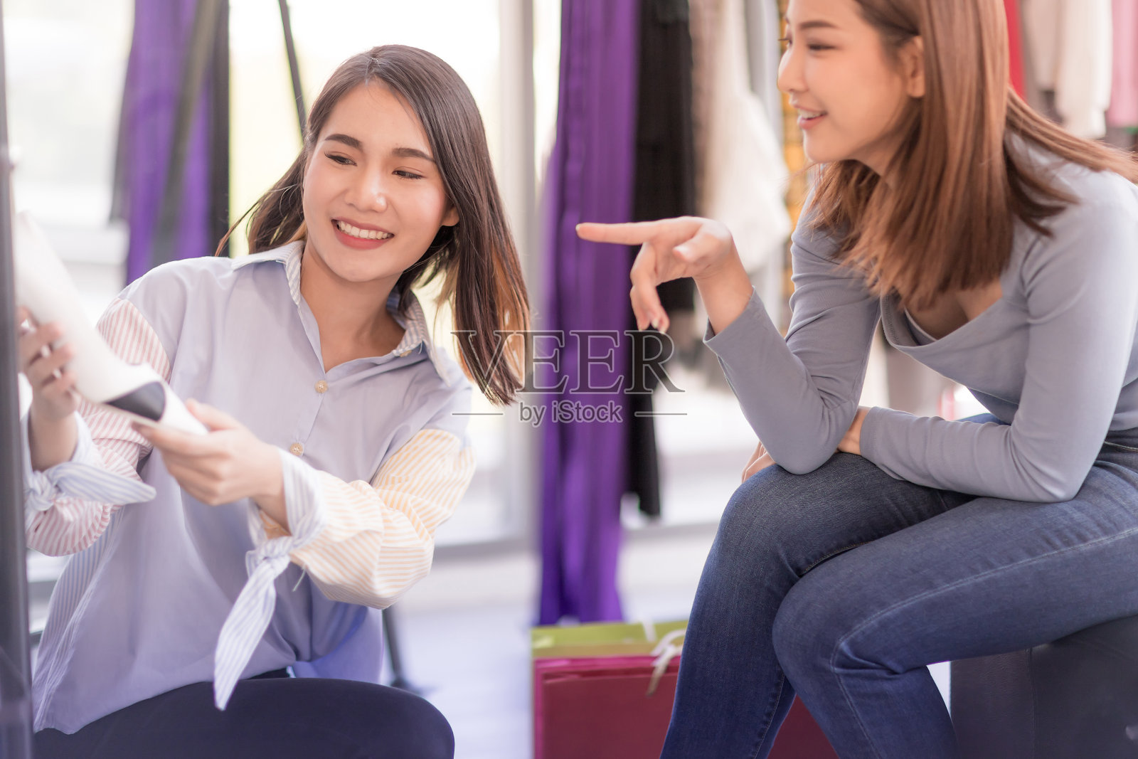 美丽的亚洲妇女在商店挑选鞋子照片摄影图片